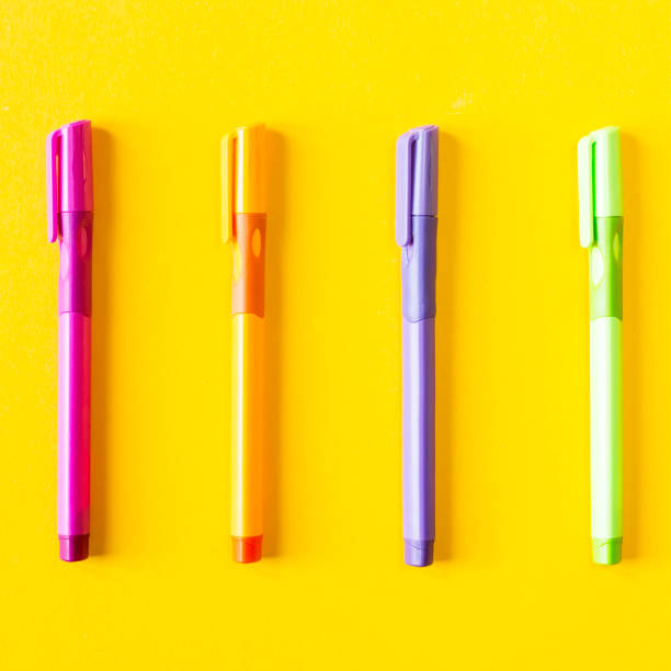 istock Multicolored four pen for writing on a yellow background . Top view, flat lay. Minimal chancery concept 986720360