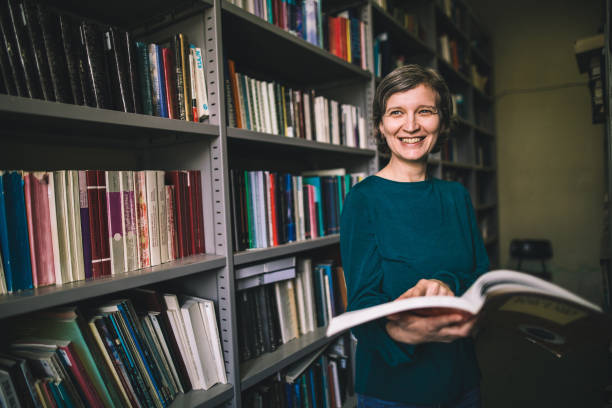 istock Mid adult librarian reading her favourite book 986720452