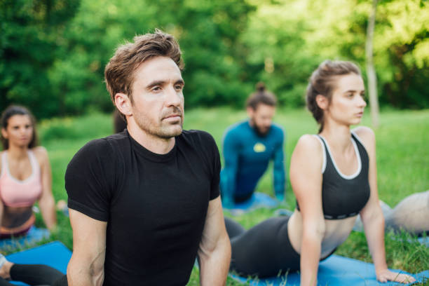 istock Handsome man exercising at the park with friends 986727010