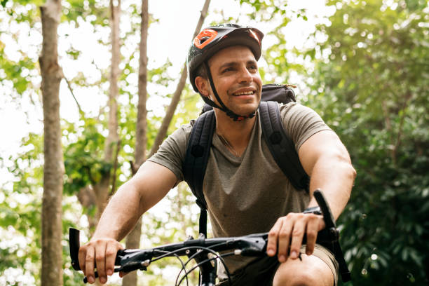 istock Happy cyclist riding through the forest 986727356