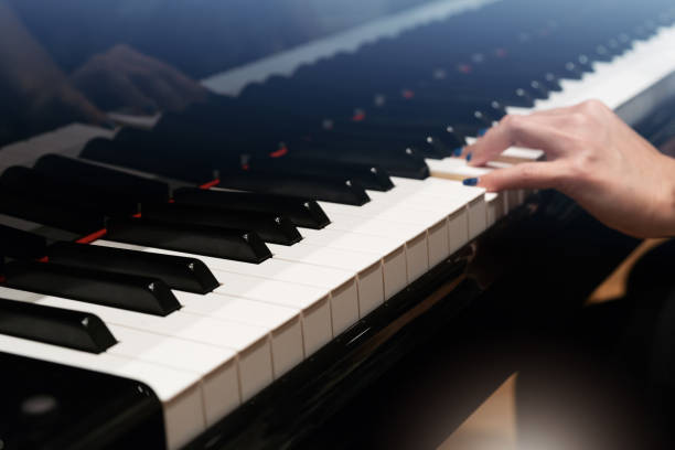 istock classic Piano keyboard with blur women hand 986728584