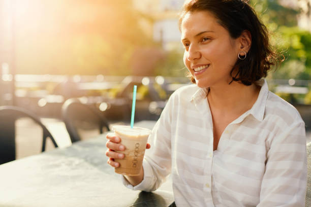istock Woman Drinking Iced Coffee 986737346