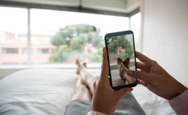 istock Woman in bed social networking on her cell phone 986740840