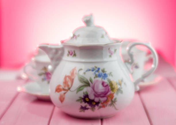 A tea set in a soft focus on a red and pink background. Selective focus.