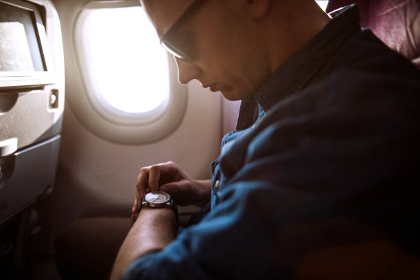 istock Traveler checking the time In Airplane 986763300