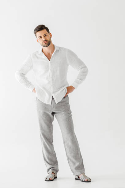 istock young handsome man in linen clothes standing akimbo isolated on grey background 986763482