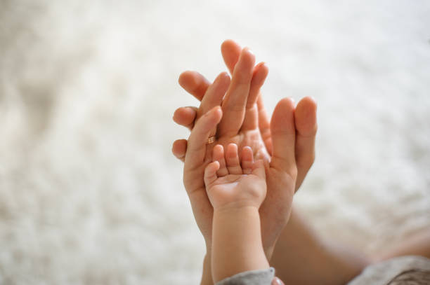 gros plan des parents et bébé des mains de jointure sur le fond clair - three boys photos et images de collection