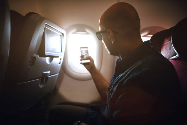 istock Traveler Taking Pictures Using Phone From Airplane 986772160