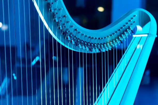 A beautiful harp on display, bathed by a blue neon light.