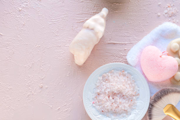 istock spa accessories and sea salt. pink background. Copy space 986847594