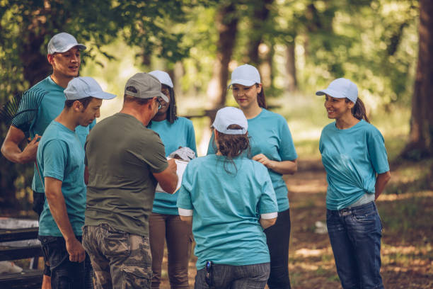 istock Group of young volunteers in public park 986892810