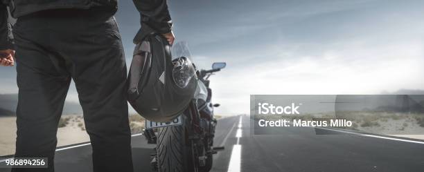 Biker With Motorcycle On A Country Road Stock Photo - Download Image Now - Motorcycle, Biker, Sports Helmet