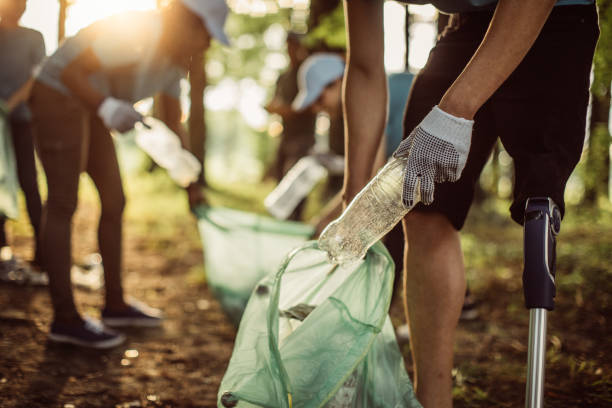 волонтеры чистят парк - green garbage bag стоковые фото и изображения