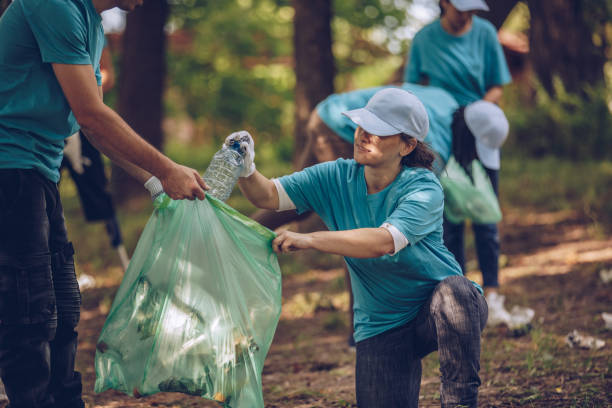 istock Young people with garbage bags cleaning public park 986901186