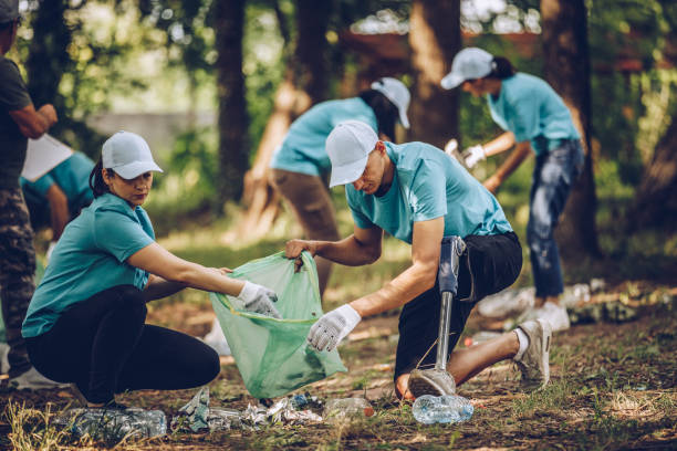 istock People with garbage bags cleaning public park 986908666