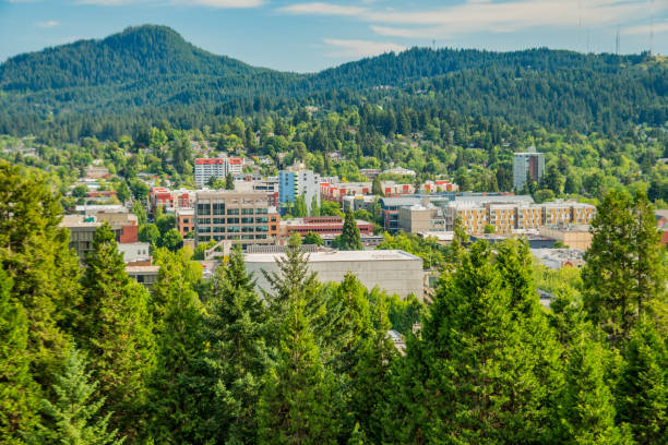 Aerial view of downtown Eugene Oregon Aerial view above downtown Eugene Oregon. Horizon is dotted with Evergreen trees and mountains with the center of the image is filled with many brick buildings lining the streets of downtown. eugene oregon stock pictures, royalty-free photos & images