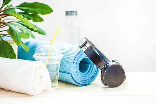 Premium Photo  Set for sports. blue yoga mat towel headphones and a bottle  of water on a light