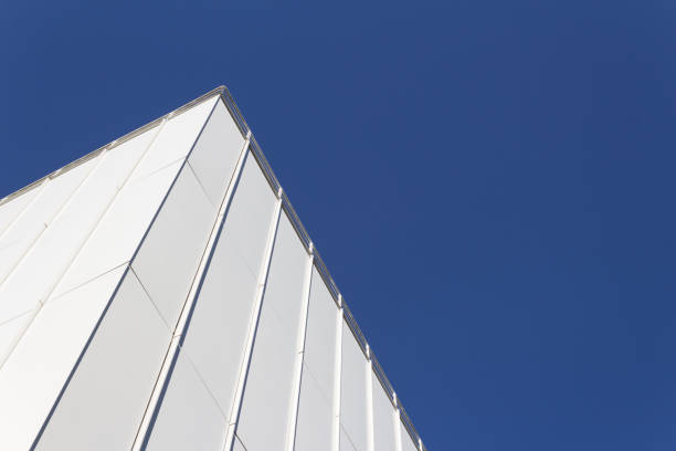 istock View looking up at corner of white generic building facade against a very deep blue sky 986929090