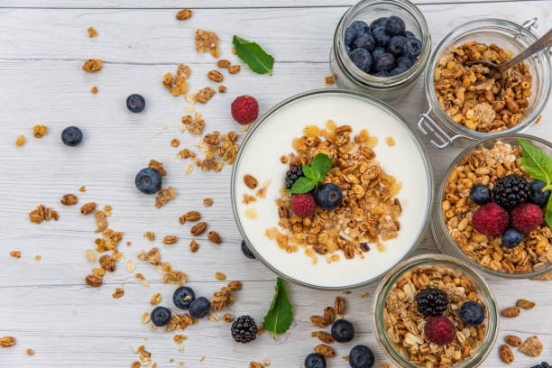 istock Jars full with granola, yogurt and fresh berries, top view, selective focus 986929326