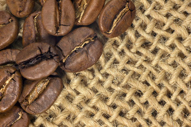 istock Coffee beans closeup on natural texture. 986934768