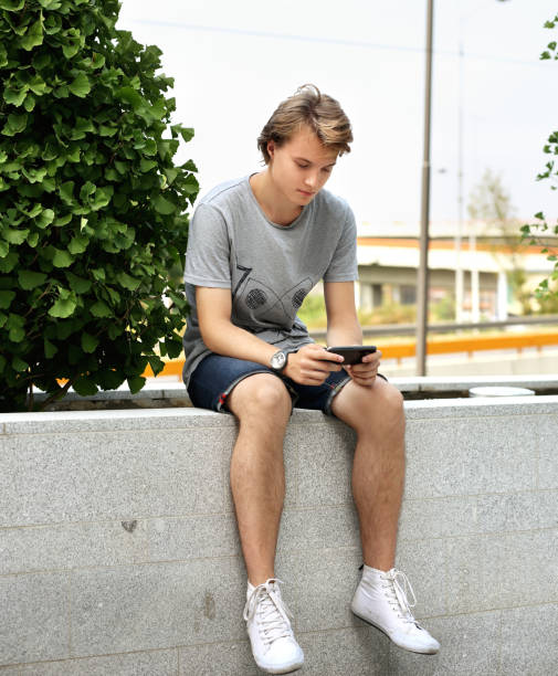 istock Using smart phone.Teenage boy typing text message. 986940398