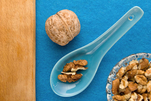 Walnuts. Top view of wooden Board and blue background. For kitchen and menu