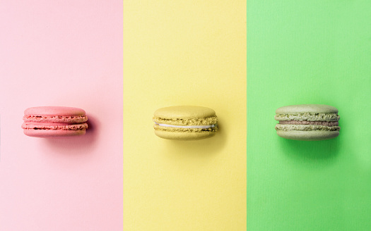 Pink, yellow and green macarons with same color background
