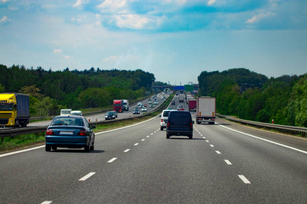 istock road with cars and blue sky with clouds 986968326