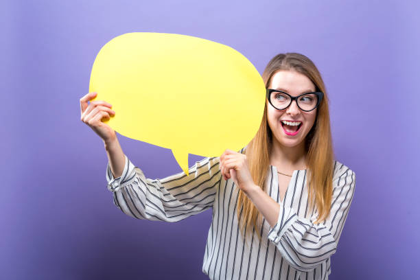 istock Young woman holding a speech bubble 986986576