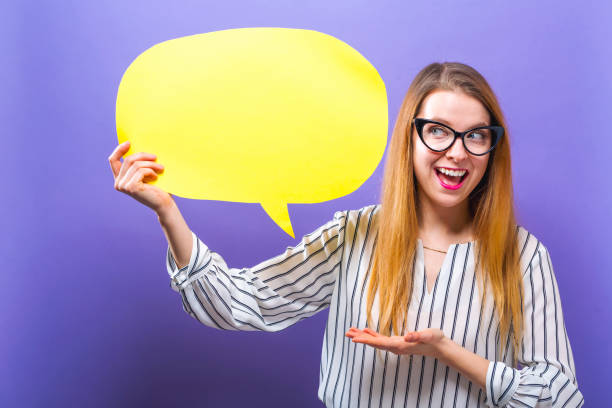 istock Young woman holding a speech bubble 986986578