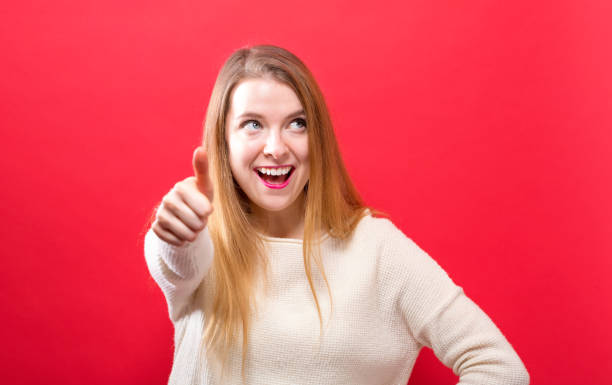 istock Happy young woman giving thumbs up 986986914