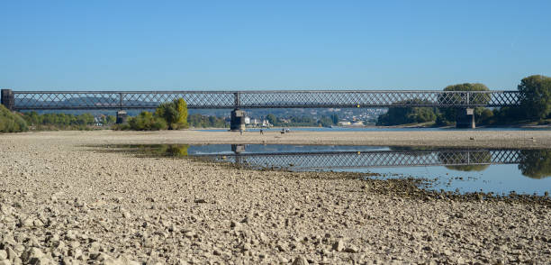 istock Dry riverbed with stones, visible old railway bridge. 986987646