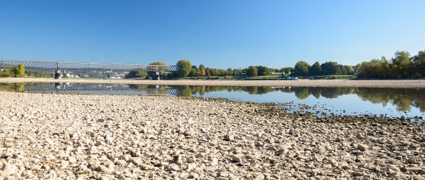 istock Dry riverbed with stones, visible old railway bridge. 986989006