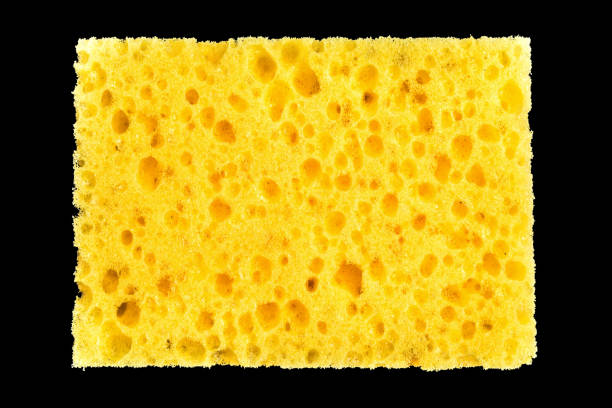 istock new yellow sponge for washing dishes on black background, abstract background 987009748