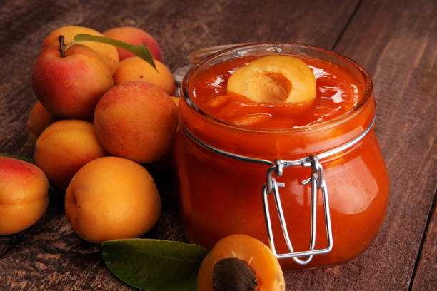 istock Jam from apricots in a glass jar on a wooden surface 987016688