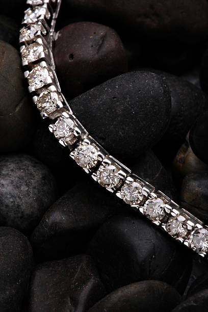 istock Diamond bracelet atop dark round rocks 98702039