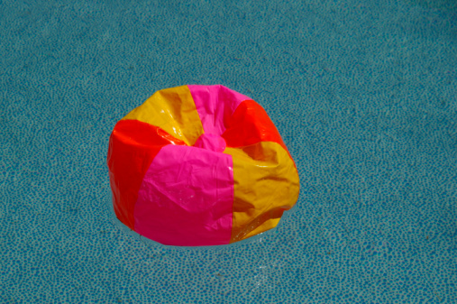 Inflatable ball on water in above ground swimming pool outdoors, closeup