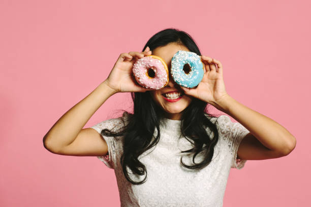 istock Girl looking through donut glasses, smiling 987024496