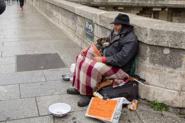 A homeless man with his dog in Paris stock photo