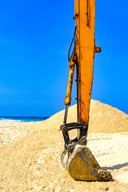 istock Yellow excavator at beach 987037206