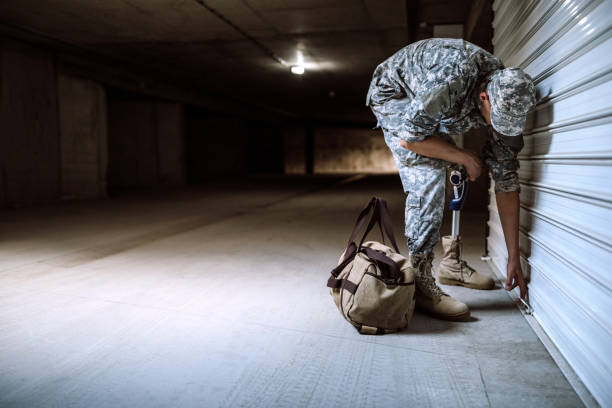 istock Young Soldier With Amputee Leg Opening Garage 987042806
