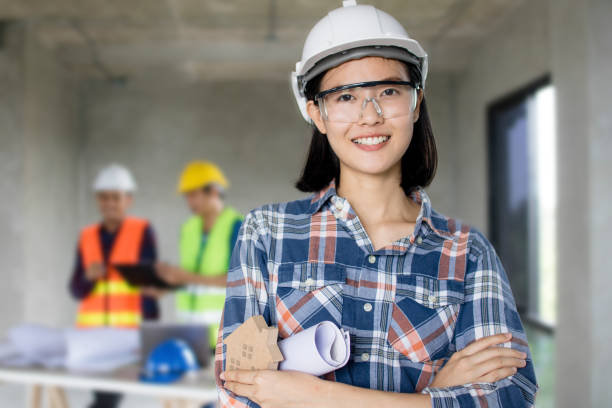 portrait of engineering women at construction site with worker working behind background stock photo