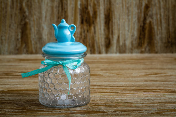 Empty glass jars with colorful lids on wooden table