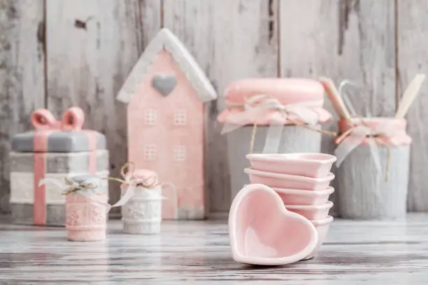 Gray and pink cute decorative kitchen utensils on white wooden background