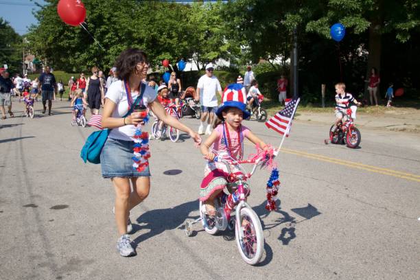 Independence Day Decorated Bike Parade Philadelphia, PA, USA - July 4, 2012: Families celebrate America's Independence Day with the annual children's decorated bicycle parade in Philadelphia's Chestnut Hill neighborhood. parade stock pictures, royalty-free photos & images