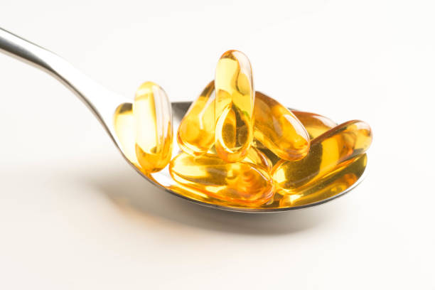 istock fish oil capsules in a spoon on white background 987111080