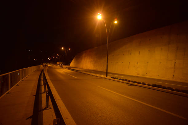 istock Multiple lane highway with pedestrian sidewalk at night 987122974