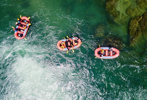 Drone point of view of men and women white water river rafting