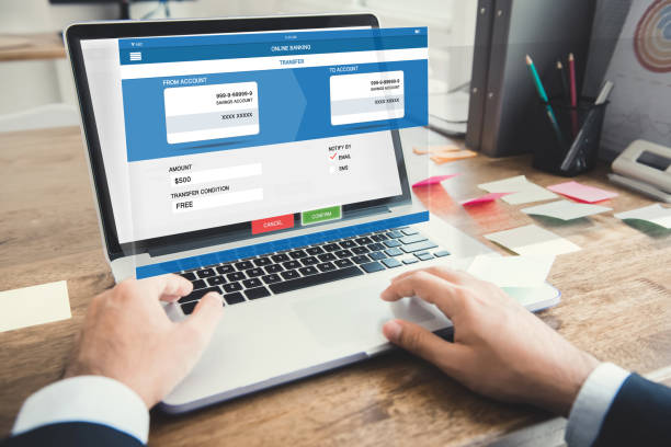 istock Businessman transferring money with internet online e-banking on laptop computer 987130298
