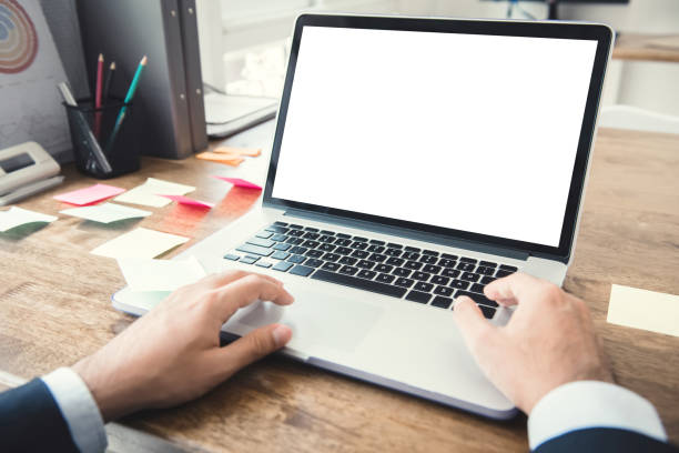 istock Laptop computer with blank empty screen being used by a businessman 987130336